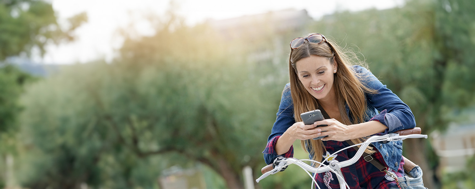 Une femme tapotant sur son smartphone pour illustrer la page de DVV sur les apps pour cyclistes.