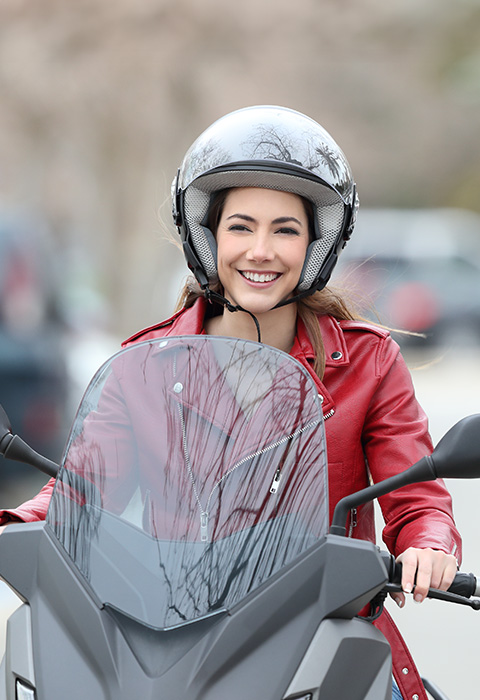 Dame op scooter op de rijbaan als illustratie voor de pagina van de verzekering tweewielers voor scooter