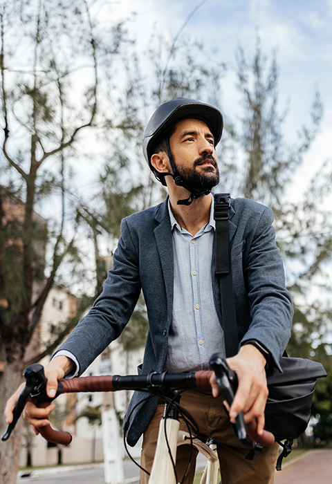 Man op de fiets in de stad in de lente als illustratie voor de pagina van de fietsverzekering van DVV 