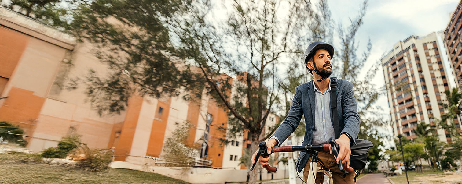 Man op de fiets in de stad in de lente als illustratie voor de pagina van de fietsverzekering van DVV 