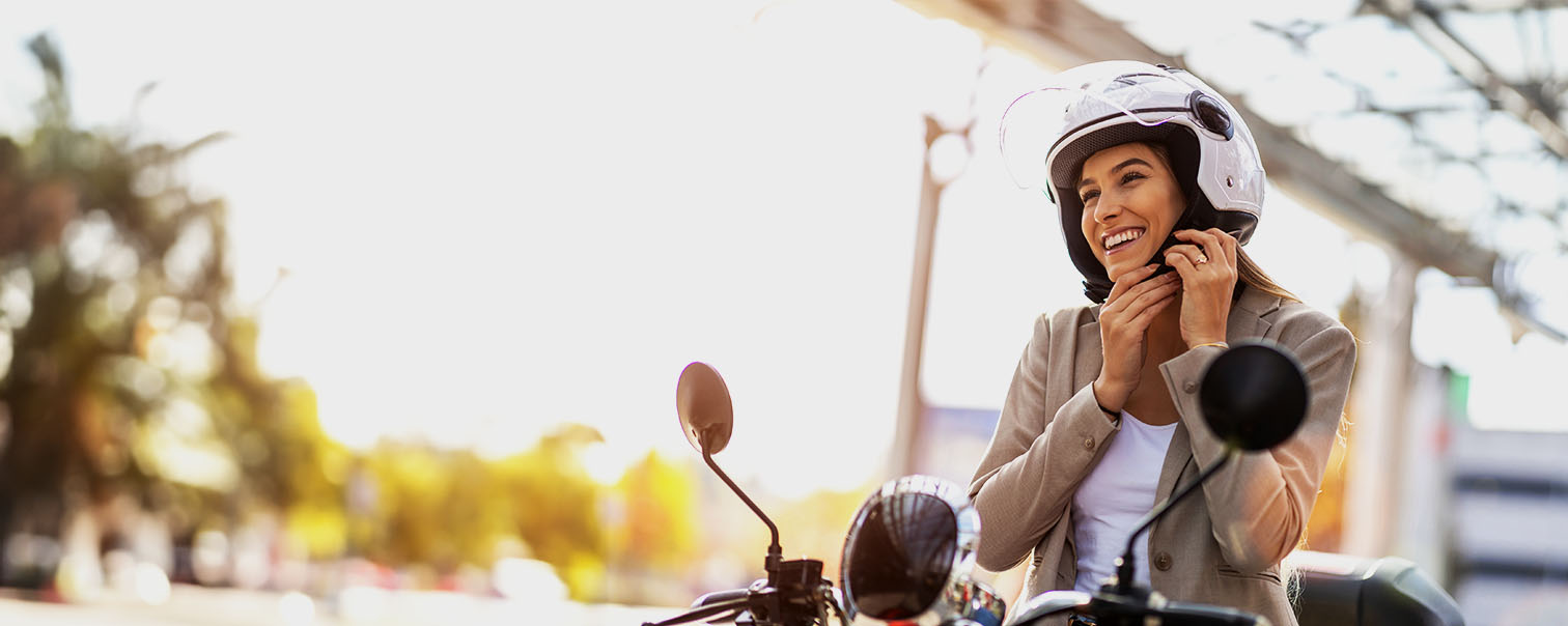 Femme sur un scooter portant un casque pour illustrer la page de l'assurance moto et scooter de DVV