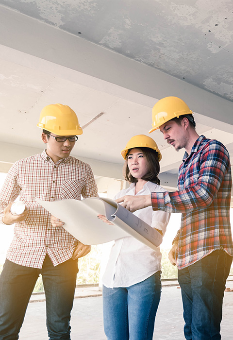 3 personnes sur chantier consultent des plans de construction illustrant les crédits hypothéfaires et solde restant dû