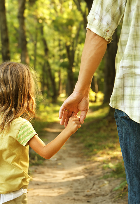 La main d'un enfant dans celle d'un parent pour illustrer la page de l'assurance obsèques de DVV
