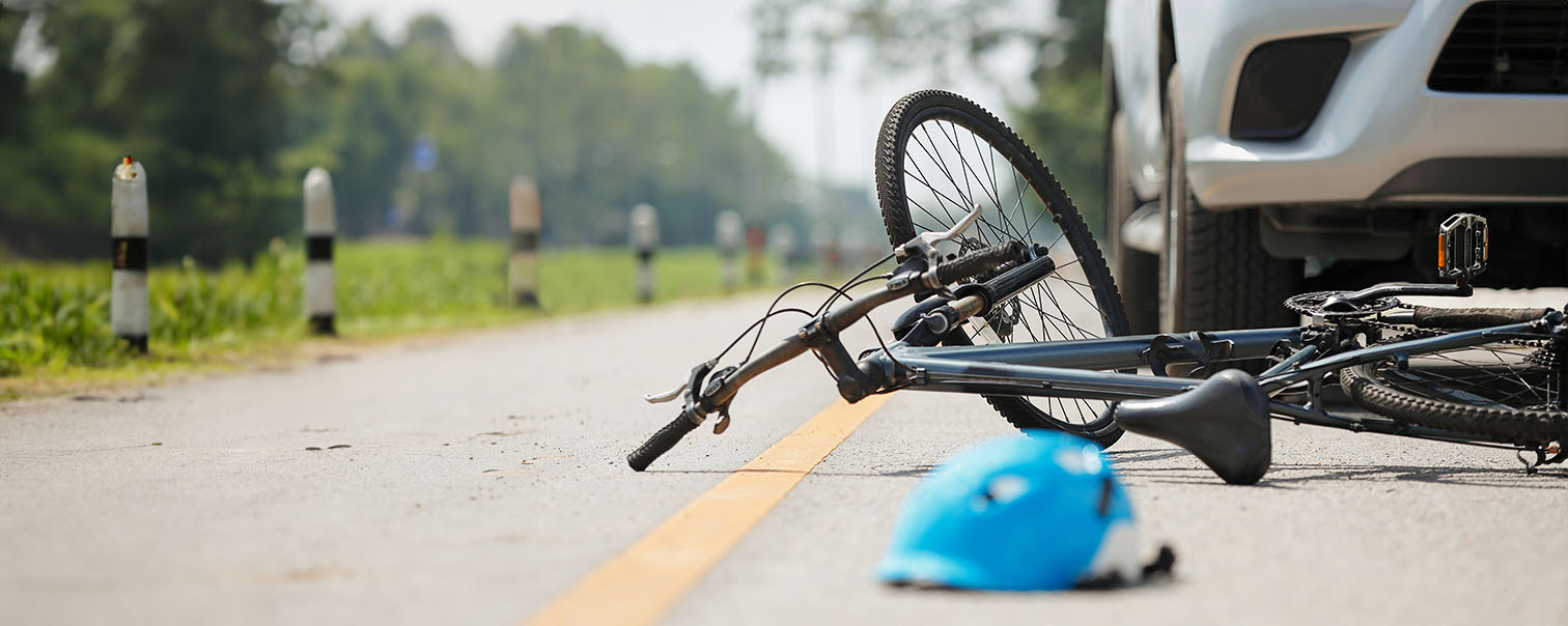 auto-ongeluk met een fiets en helm op de grond als illustratie voor de pagina van de verzekering verkeer van DVV 