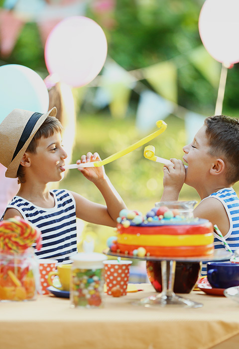 Twee kindjes spelen en lachen op een feestje als illustratie voor de pagina verzekering Tijdelijke activiteiten van DVV 
